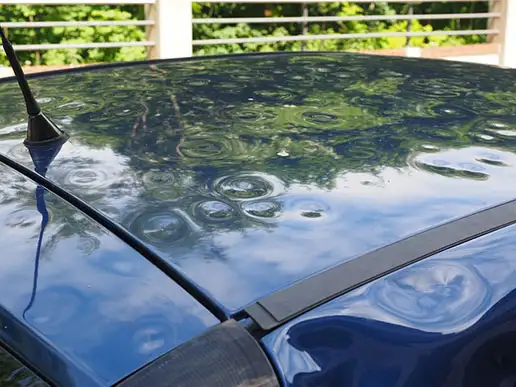 The top of a vehicle is completely covered in small dents.